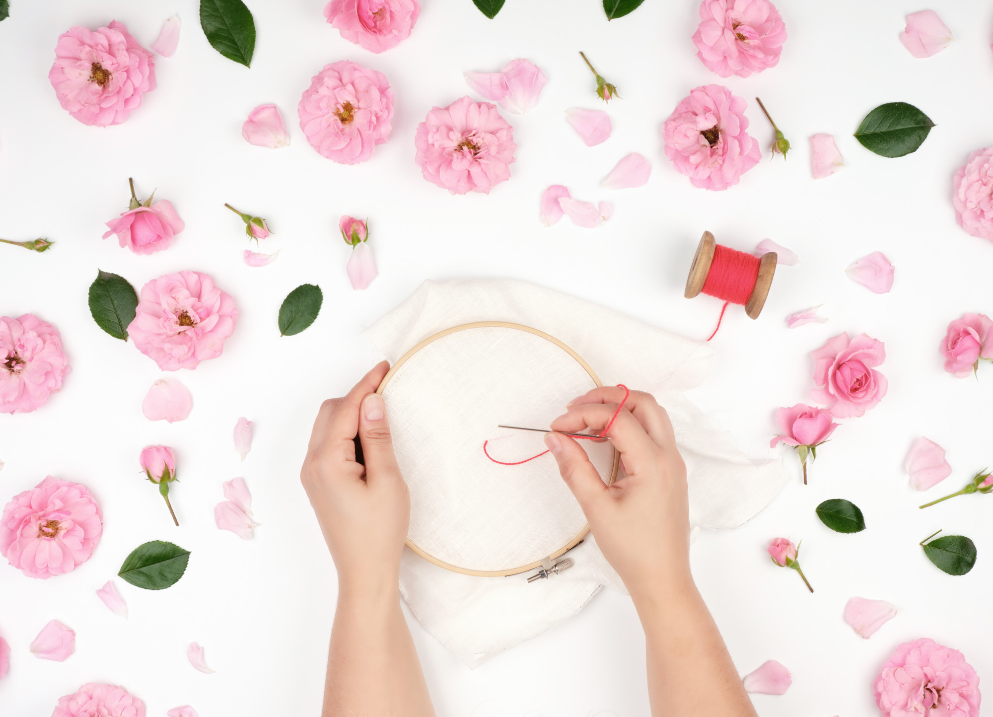 mână care brodează model floral pe pânză